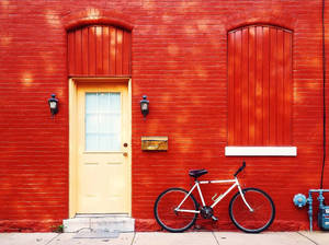Bicycle On Red Brick Façade Wallpaper