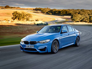 Blue Bmw Driving In A Rural Area Wallpaper