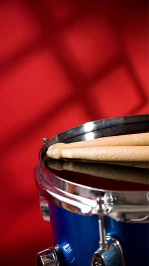 Blue Drumwith Drumsticks Red Background Wallpaper