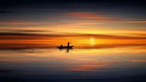 Boat Silhouette At Ocean Sunset Wallpaper