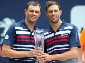 Bob Bryan And Mike Bryan Raise Their Trophy In Triumph Wallpaper