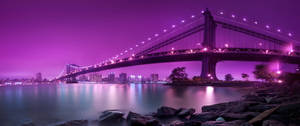 Breathtaking Ultra Wide 4k View Of A Purple Illuminated Bridge Wallpaper
