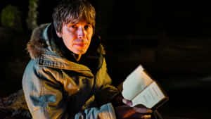 Brian Cox Holding Book Nighttime Wallpaper