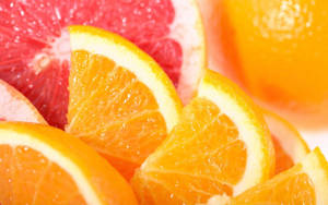 Bright And Fresh Sliced Citrus Fruits - Grapefruits And Oranges Wallpaper