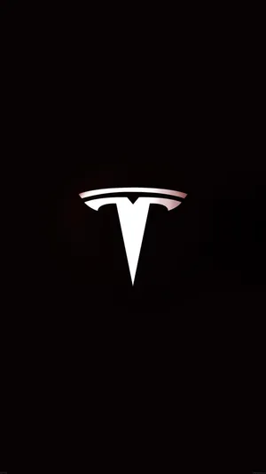 Bright Tesla Logo Against A Dark Background Wallpaper