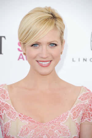 Brittany Snow Smiling In Front Of A Pink Backdrop Wallpaper