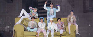 Bts Concert With Members On A Couch Wallpaper