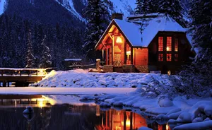 Cabin Covered In Snow At Night Wallpaper