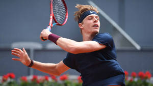 Canadian Tennis Star Denis Shapovalov In Dynamic Action Wallpaper