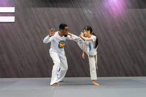 Capoeira Coach Teaching A Student Wallpaper