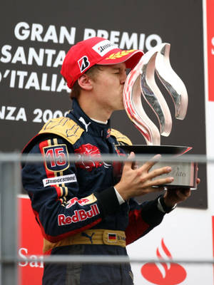 Caption: Celebrated F1 Racer, Sebastian Vettel, Kissing His Coveted Trophy Wallpaper