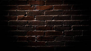 Caption: Deep Brown Brick Texture Under Dim Light Wallpaper