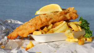 Caption: Delicious Golden-brown Fish And Chips Wallpaper