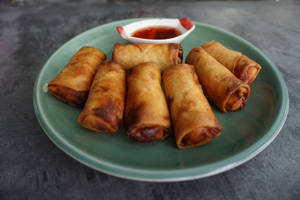 Caption: Deliciously Crisp Egg Rolls On A Simple Plate Wallpaper