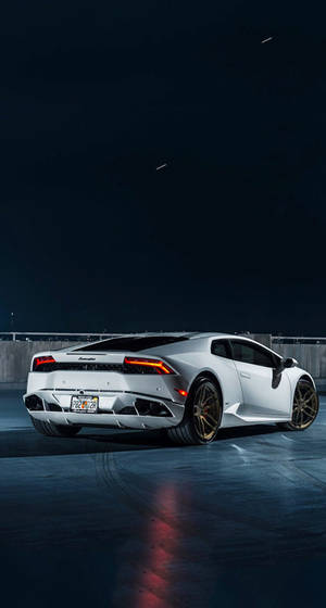 Caption: Exclusive Lamborghini Parked In A Rooftop Parking Lot - Perfect Iphone Wallpaper Wallpaper
