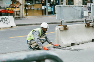 Caption: Hard-working Construction Worker In Action Wallpaper