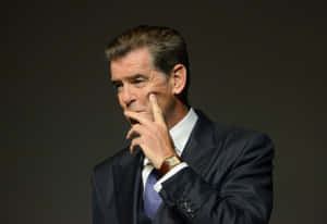 Caption: Iconic Pierce Brosnan In A Thoughtful Pose Wallpaper
