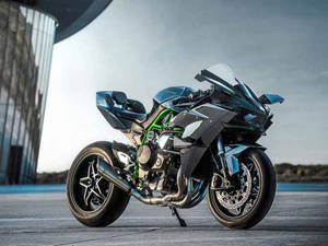 Caption: Majestic Kawasaki H2r Parked Outside A Stylish Building Wallpaper