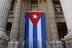 Caption: Majestic Mansion Under The Emblematic Cuban Flag Wallpaper