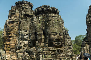 Caption: Majestic Stone Faces In Angkor Wat, Cambodia Wallpaper