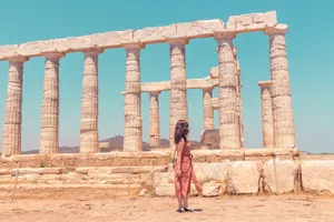 Caption: Majestic Temple Of Poseidon In Sounion Under A Serene Sky Wallpaper