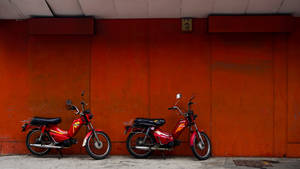 Caption: Sleek Red Bike In An Urban Setting Wallpaper