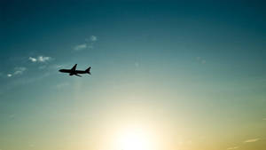 Caption: Soaring The Skies: A Small Black Plane High Up In The Air Wallpaper