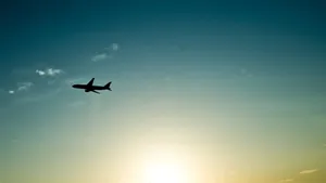 Caption: Soaring The Skies: A Small Black Plane High Up In The Air Wallpaper