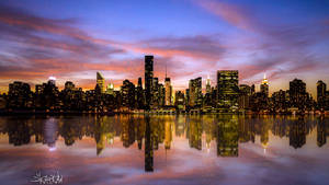 Caption: Stunning Skyline View Of Manhattan At Sunset Wallpaper