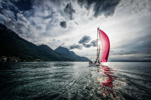 Captivating Serenity: A Blue Sailboat On Peaceful Sea Wallpaper