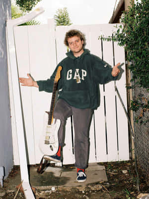 Casual Musicianwith Guitar Outdoors Wallpaper