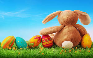 Celebrate Easter With Joyful Bunny And Colored Eggs Wallpaper