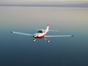 Cesna 400 Small Airplane Gliding Over Water Wallpaper