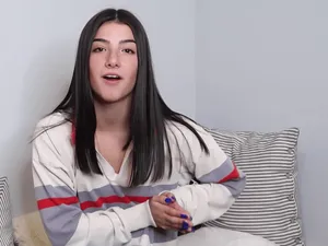 Charli Damelio Sitting On A Sofa Wallpaper