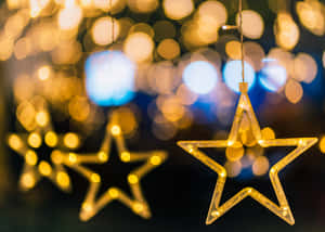 Christmas Star Decorations Hanging From A Window Wallpaper