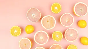 Citrus Fruit Assortment Pink Background Wallpaper