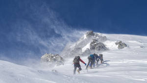 Climbing Group On Snowy Mountain Wallpaper