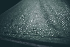Close-up Of Glistening Water Droplets On A Reflective Surface Wallpaper