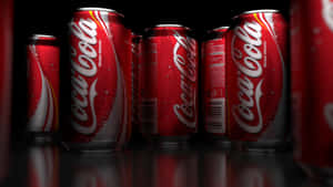 Coca Cola Cans On A Black Background Wallpaper