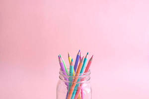 Color Pencils In Jar With Pastel Pink Color Background Wallpaper