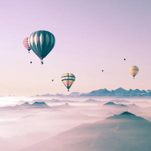 Colorful Hot Air Balloons Soaring In A Beautiful Sky Displayed On A Cute Ipad. Wallpaper