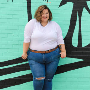 Confident Plus-size Woman Posing In A Green Background Wallpaper