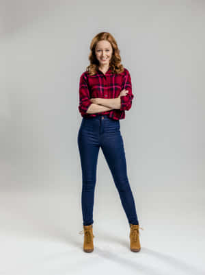 Confident Womanin Plaid Shirtand Jeans Wallpaper