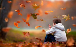 Cool Sad Boy Sitting On Leaves Wallpaper