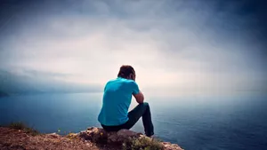 Cool Sad Boy Wearing Blue Shirt Wallpaper