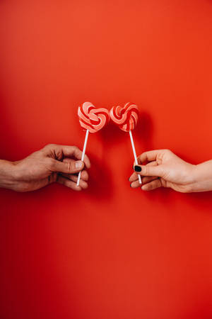 Couple Hands Heart Shaped Lollipops Wallpaper