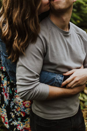 Couple Hugging With Kiss On The Cheek Wallpaper