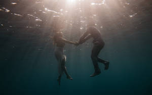 Couple Swimming Under The Ocean Wallpaper