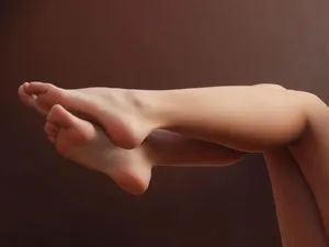 Crossed Bare Legs Brown Background Wallpaper