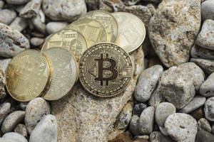 Cryptocurrency Coins On Rocks Wallpaper